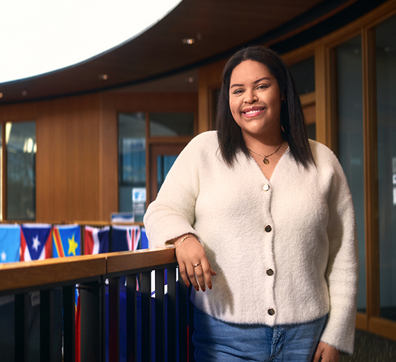 Женщина стоит с скрещенными руками рядом с окном